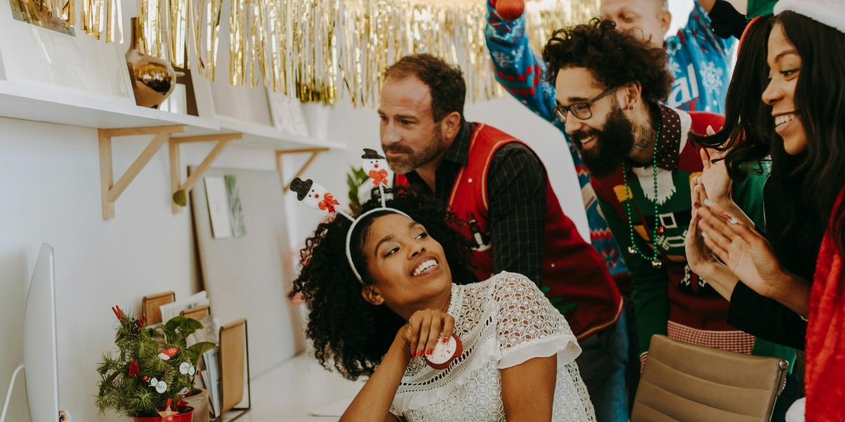 A diverse team shares a moment of laughter and connection during a virtual or hybrid meeting.