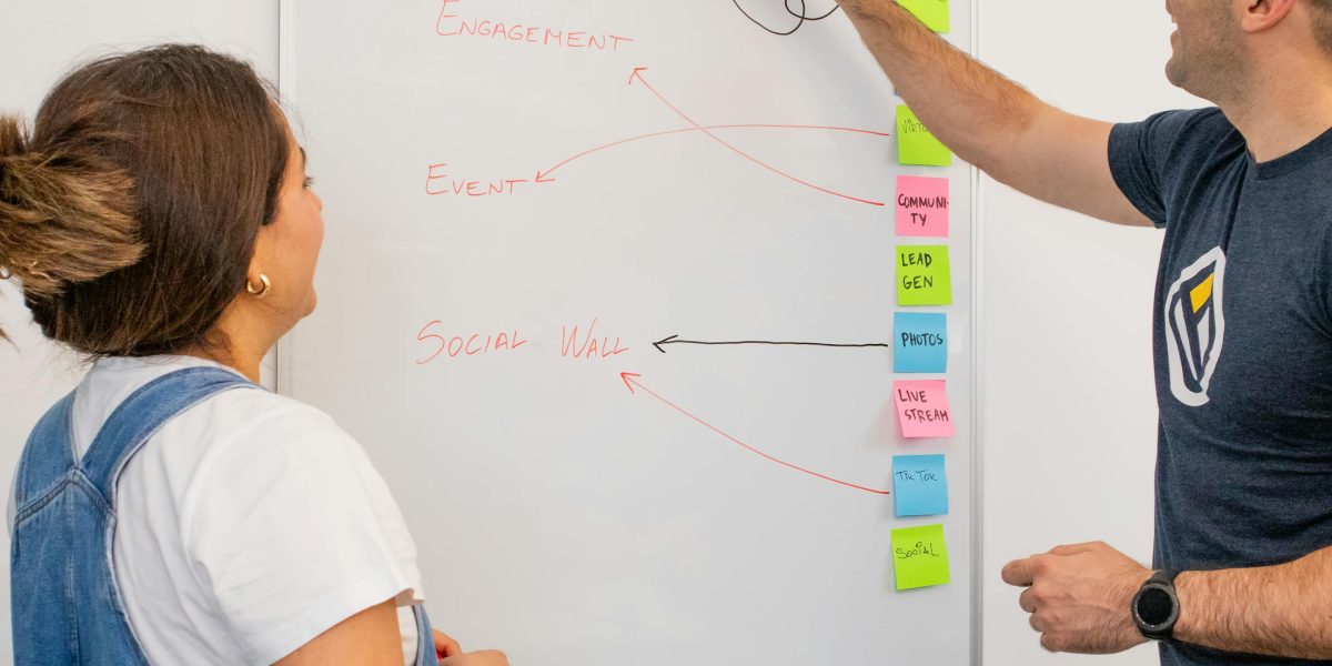A diverse group of professionals actively collaborating around a whiteboard, emphasizing shared goals.