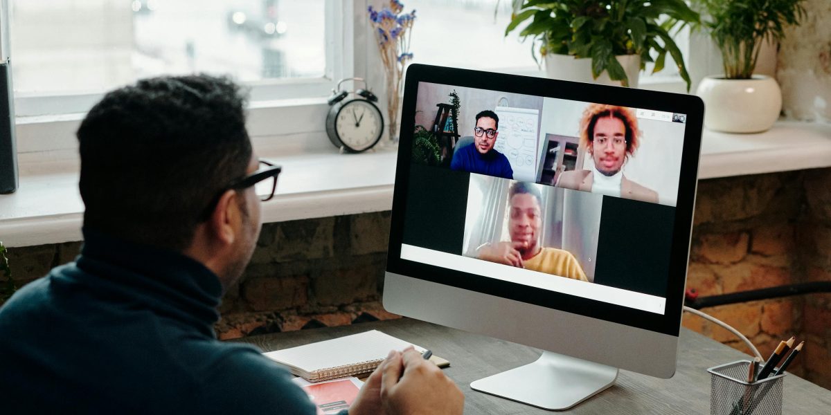 Remote team members laughing together during a virtual meeting, fostering connection.